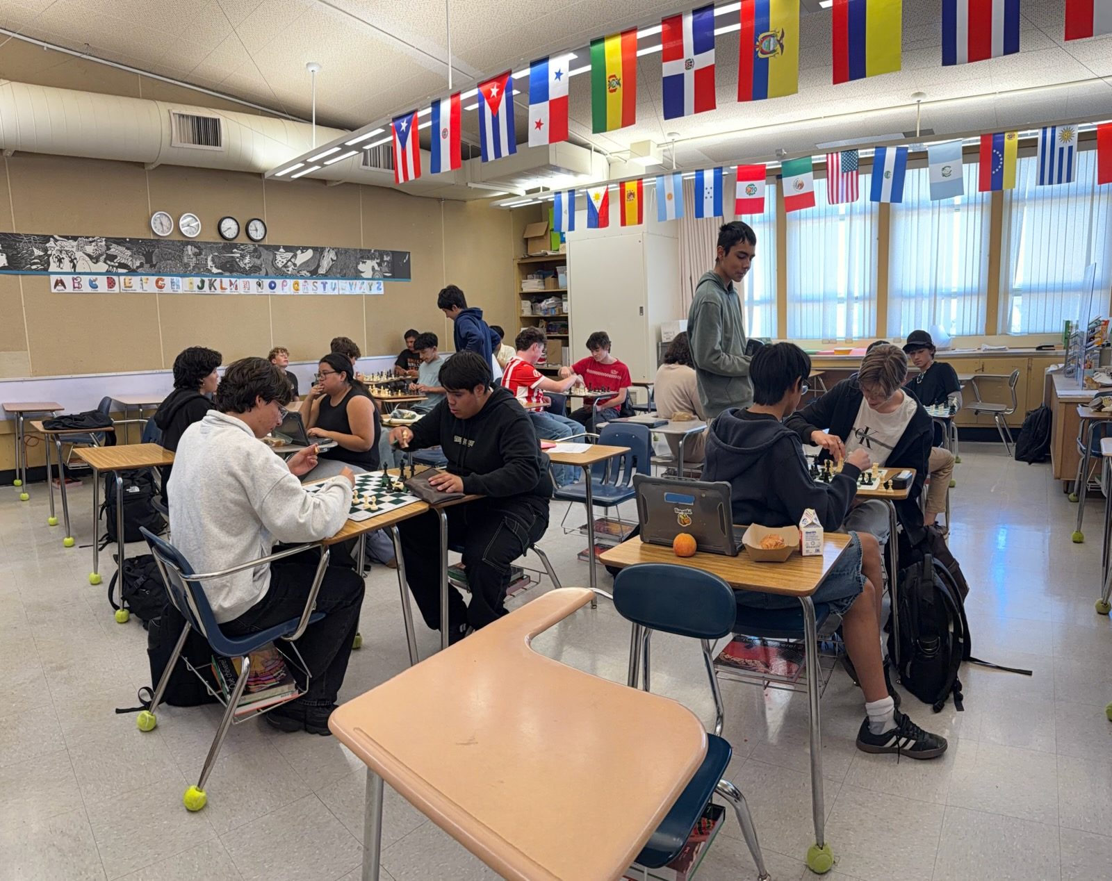 College Park High School chess club playing at desks in a classroom hung with international flags