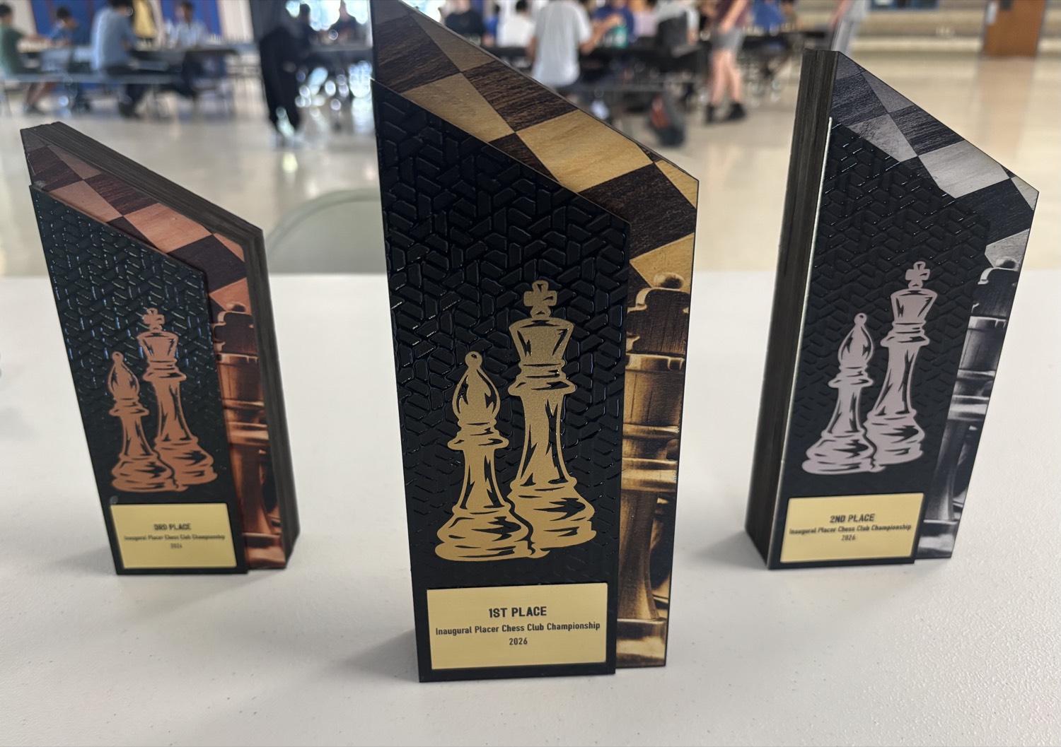 First, second, and third place trophies engraved Inaugural Placer Chess Club Championship 2026